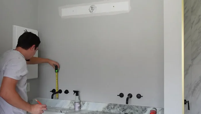 Measure where the new light fixtures will be placed (centered on mirrors/sink). Create cardboard templates for mirror placement to aid in fixture positioning.