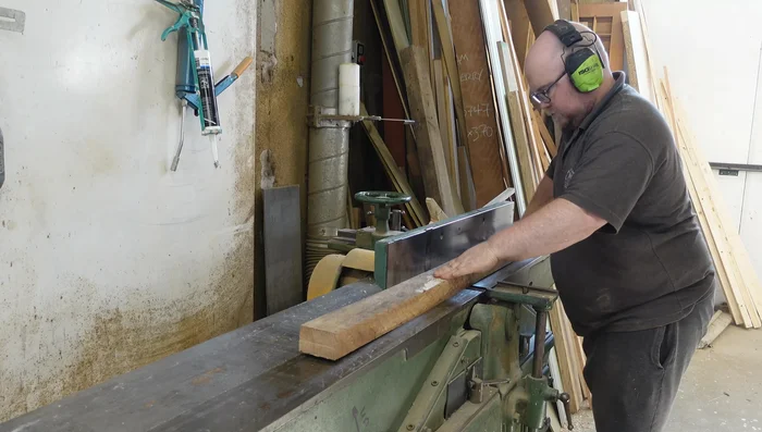 Rough cut the boards to manageable sizes for the panel saw. Use the saw's fence with a simple plywood backing piece and reference lines for accurate cuts.