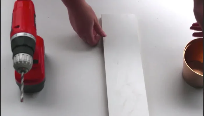 Drill holes at the marked spots using the drill and a hard surface.