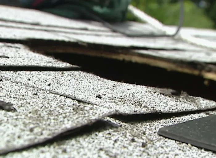 Apply silicone sealant around the flashing and under the shingles.