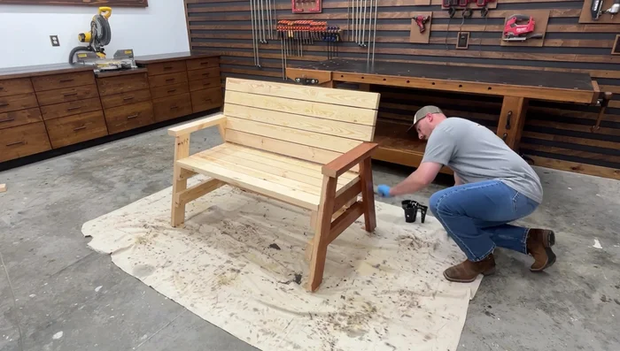 Apply a waterproof deck stain, outdoor clear coat, or paint to protect the bench from the elements.