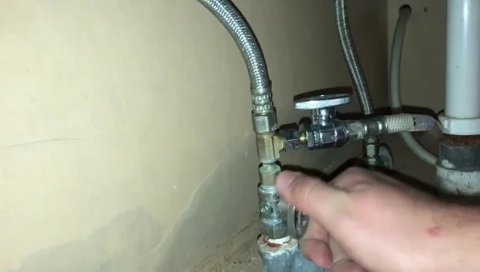 Turn off the water supply valve under the sink for the affected hose (hot water in this example).