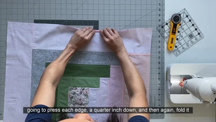 Finish the edges by pressing a quarter-inch hem, folding again, and pressing. Edge stitch the hem in place.