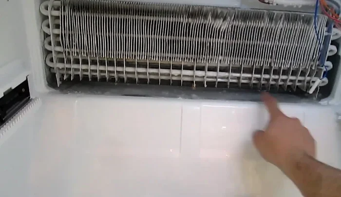 Locate the drain plug: The drain hole is located in the center of the metal tray underneath the cooling unit.