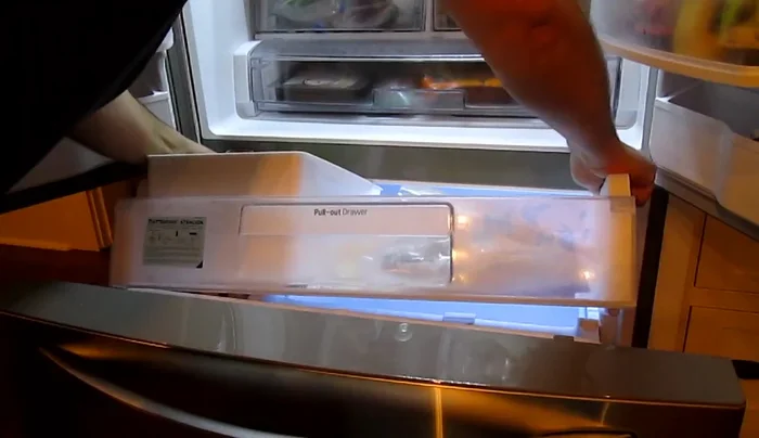 Remove ice buildup: Open the refrigerator and freezer drawers. Use a cake pan or cookie sheet to collect ice from the bottom, breaking it up by hand.