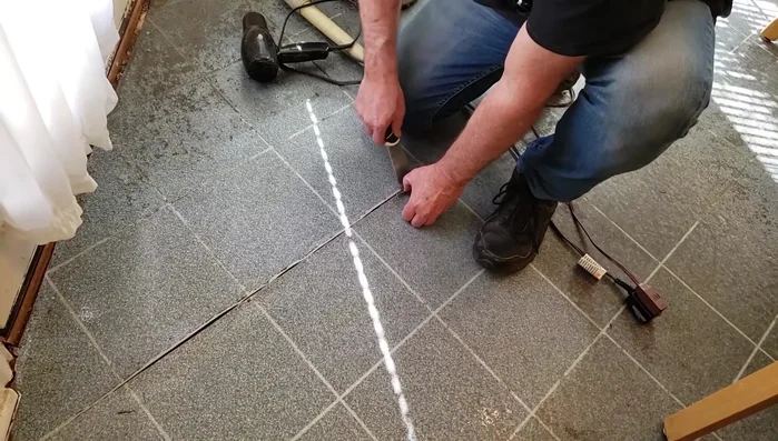 Clean out old adhesive and debris from underneath the separated linoleum seam using a scraper.