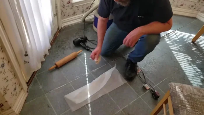 Place a flat piece of wood over the seam and apply significant weight (bricks, cinder blocks, etc.) for at least 12 hours to allow the adhesive to cure.