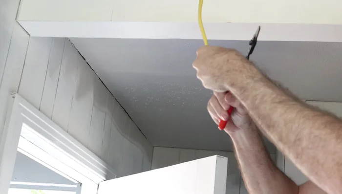 Strip the ends of the Romex cable and connect them to the corresponding wires in the light cans (black to black, white to white, ground to ground).