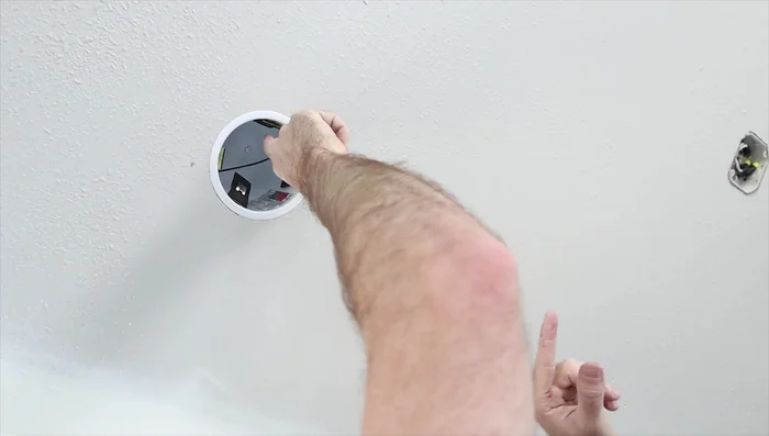 Install the light cans in the ceiling holes, pushing the tabs upwards to secure them firmly.