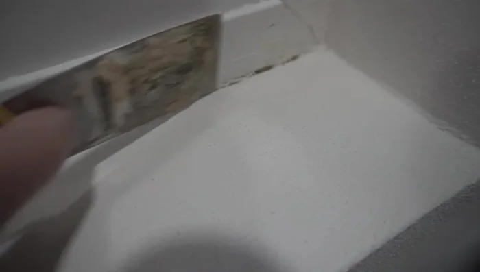 Clean up excess texture with a putty knife and wet rag. Caulk edges for a smooth finish.