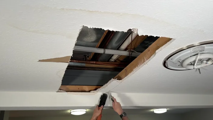 Cut out damaged drywall, using a jig to ensure precise cuts.