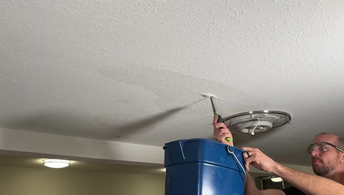 Cut small holes in the ceiling to drain standing water and assess the situation.