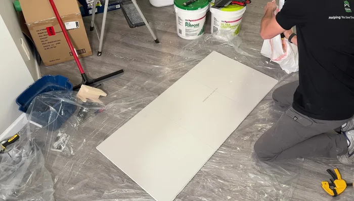 Apply knockdown texture, letting it set before knocking down with a wet knife.