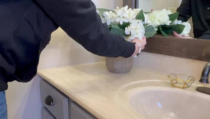 Place a vessel with hydrangeas on the vanity, and add hand towels.