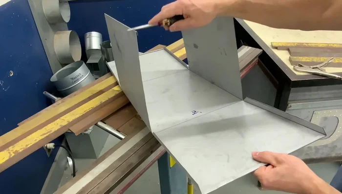 Opening the hems slightly: Slightly open the hems to receive the corner lap seam.