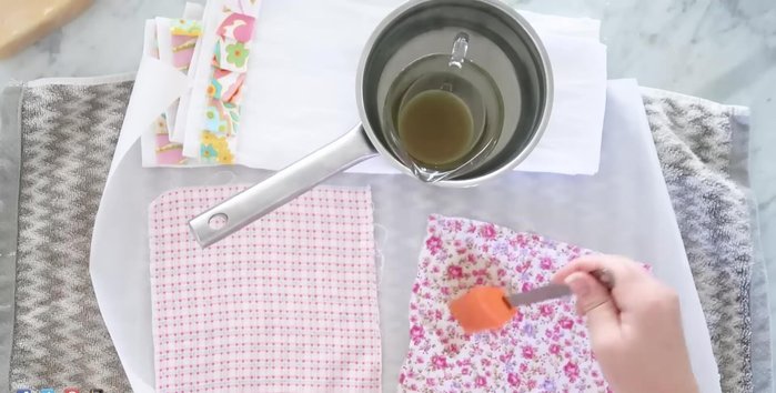 Place fabric squares on parchment paper. Brush the melted wax mixture onto the fabric, spreading from the center outwards.